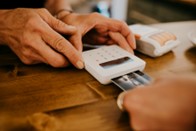 Hands inserting a bank card into a card reader