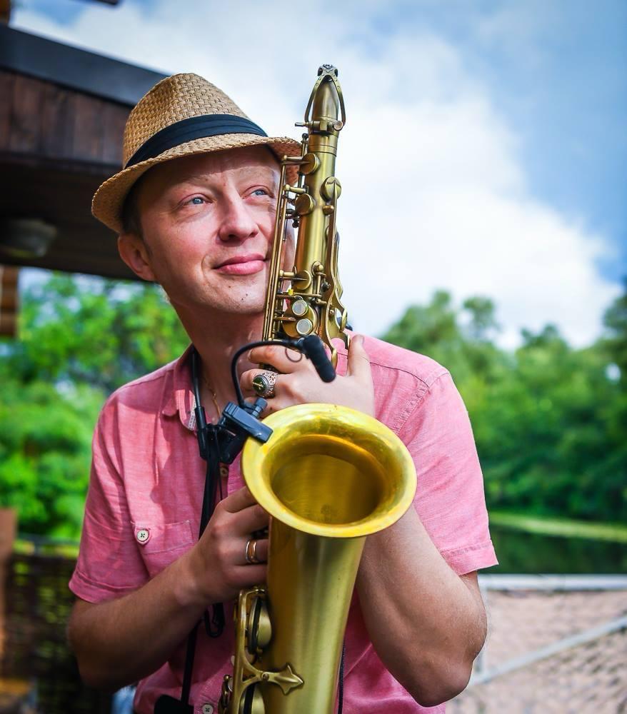 Musician Alex holding a saxophone