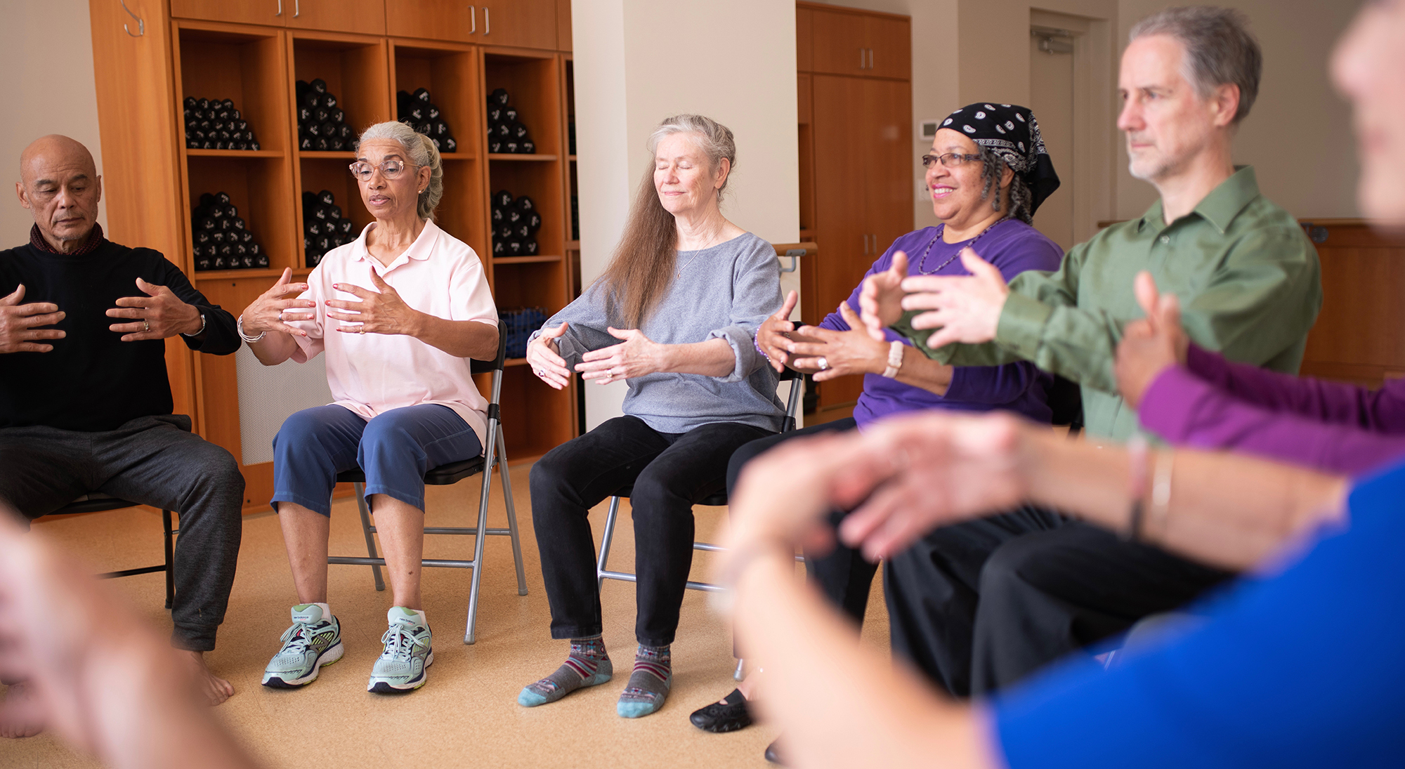 Group of seated people practising Tai Chi