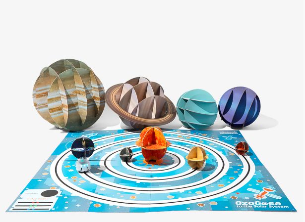 Flat board marked with concentric circles representing planet orbits with constructed ball shapes as planets