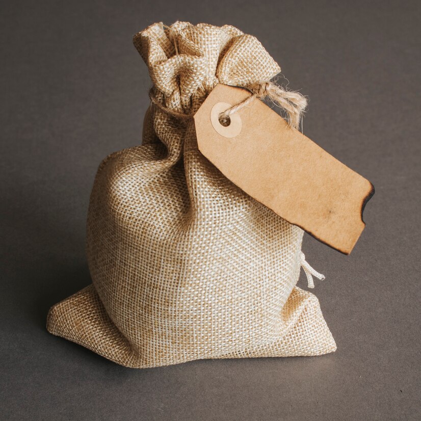 An unmarked mini sack bag tied at the top with a brown parcel label attached