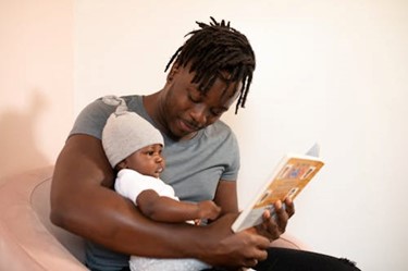 Man holding baby reading book
