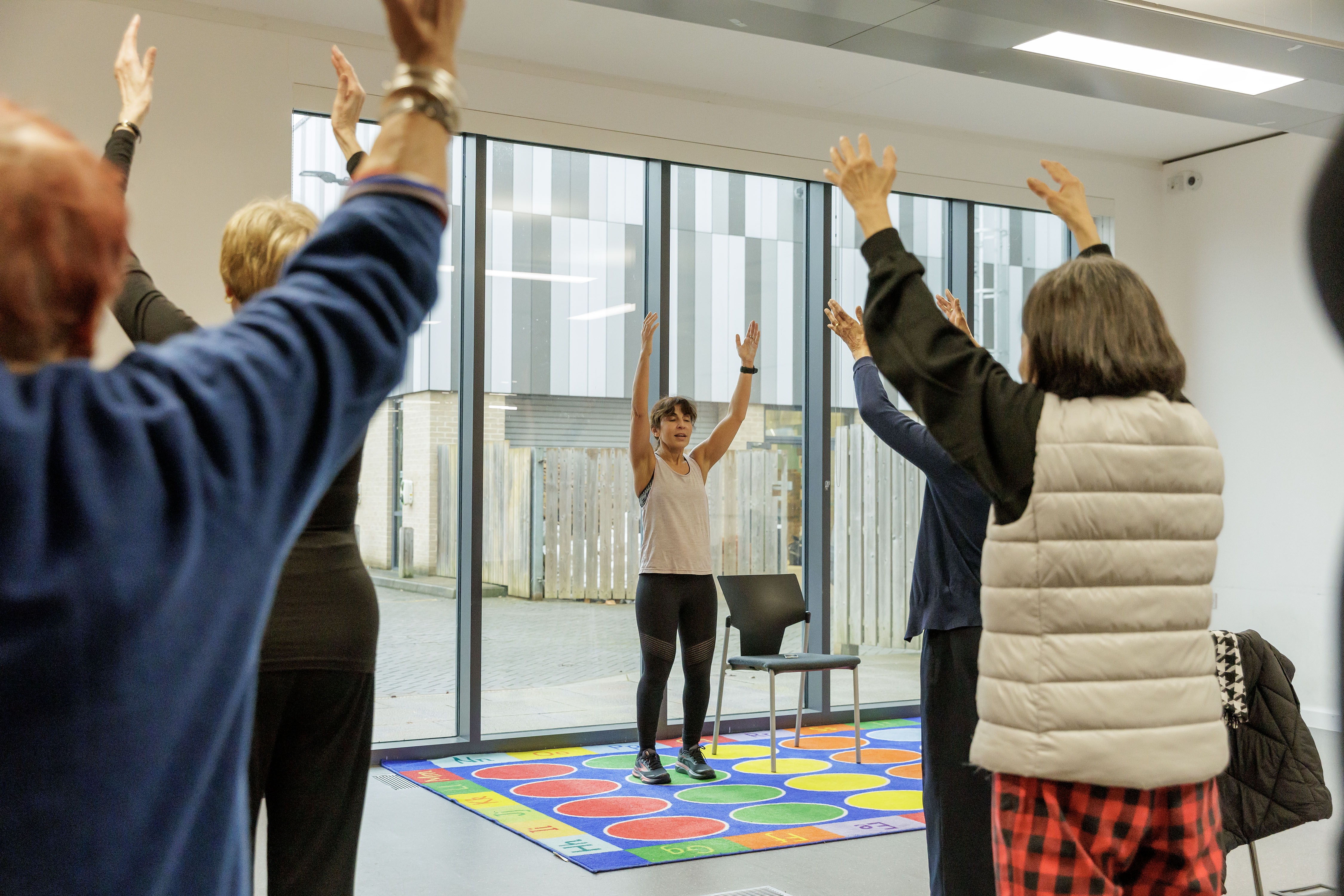 A group doing Tai Chi with their arms lifted