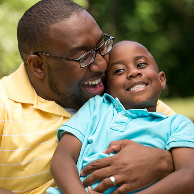 Happy man cuddling a smiling boy