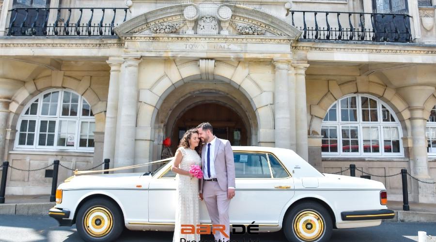 Couple with white wedding car outside Hendon Town Hall