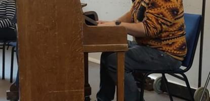 Figure seated at piano